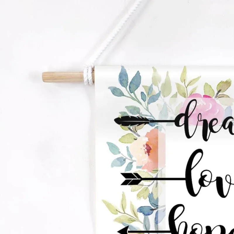 Close-up of floral printed canvas wall hanging with wooden rod and rope hanger