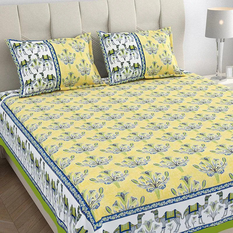 Close view of yellow floral bedsheet and matching elephant-patterned pillow covers