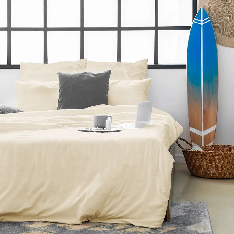 Ivory bedsheet spread on a bed with matching pillow covers in a bright room