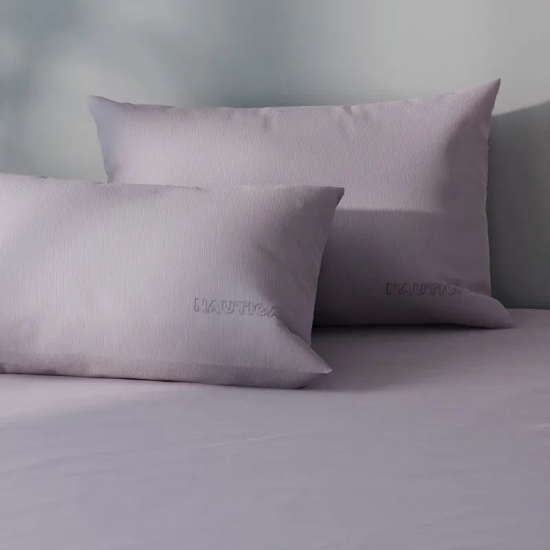 Close-up of light pink cotton pillow covers and matching solid bedsheet