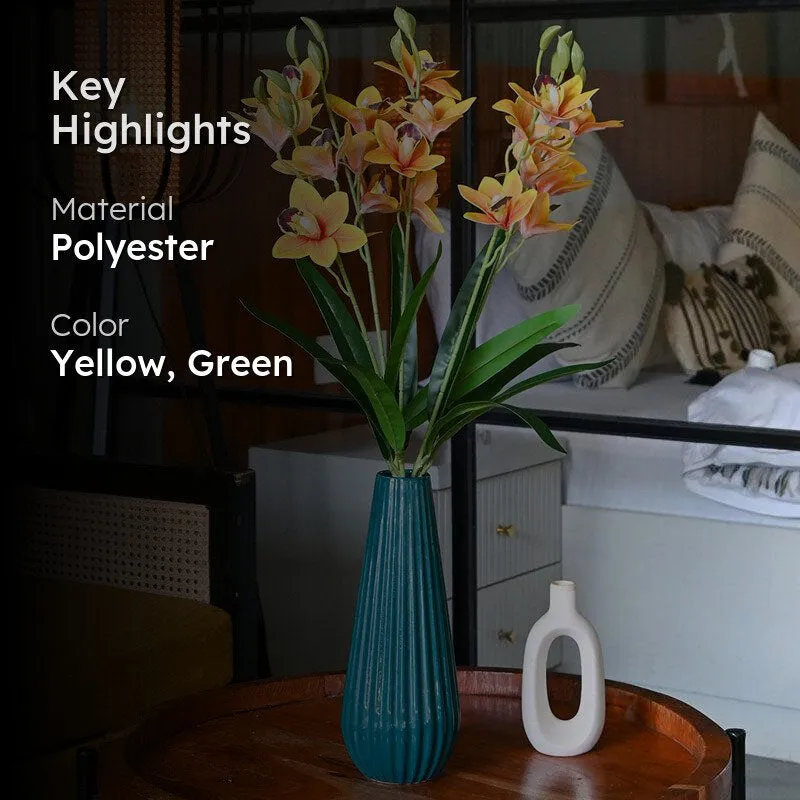 Artificial yellow orchid arrangement shown in a vase in a living room