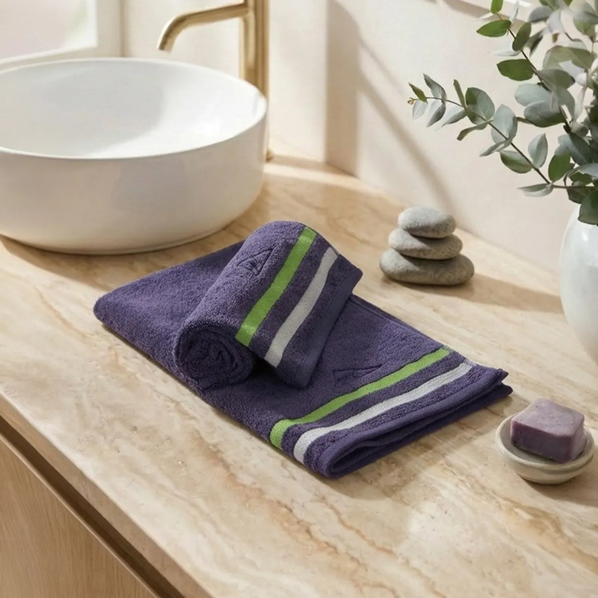 Two blue striped towels folded beside a wash basin on a marble counter