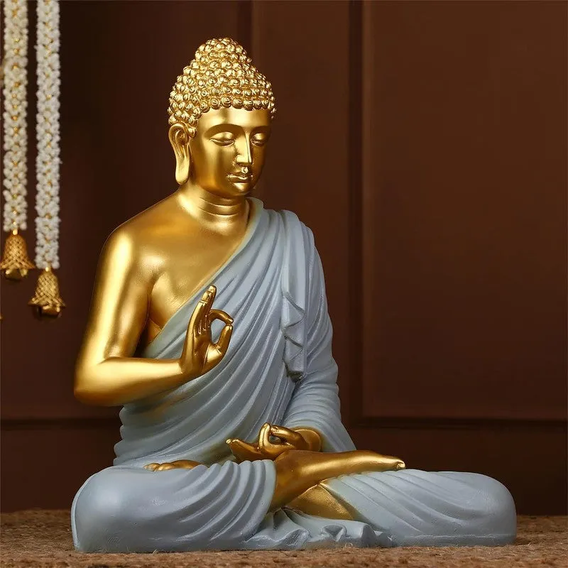 Angled view of Buddha idol with grey draped robe and gold finish