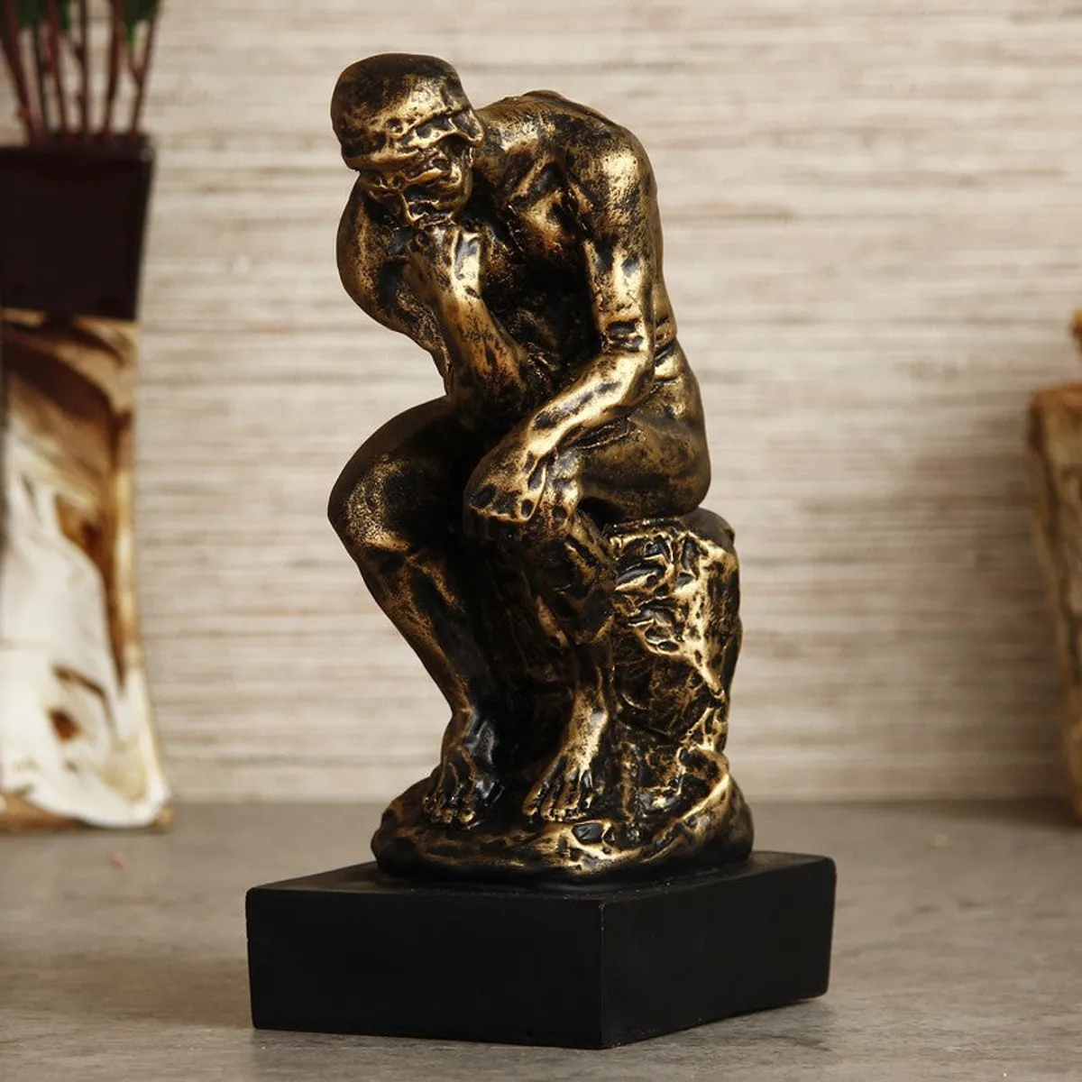 Close view of gold and black thinker showpiece on a black base