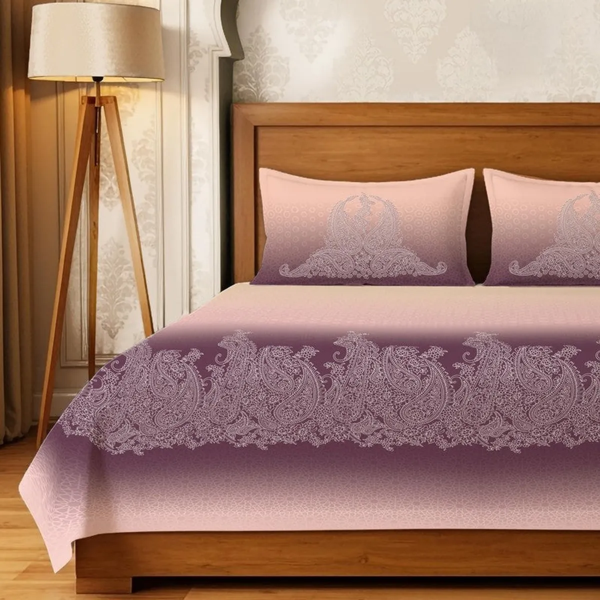 Close view of pink and purple bedsheet with detailed paisley-style border and matching pillow covers