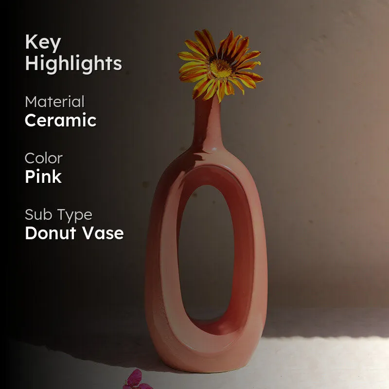 Pink ceramic vase with a yellow flower against a darkened background