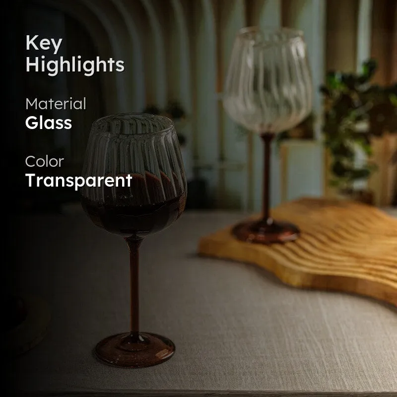Ribbed clear wine glass with tawny stem on a dining table
