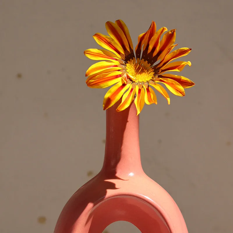 Close-up of a yellow flower placed in a pink ceramic vase