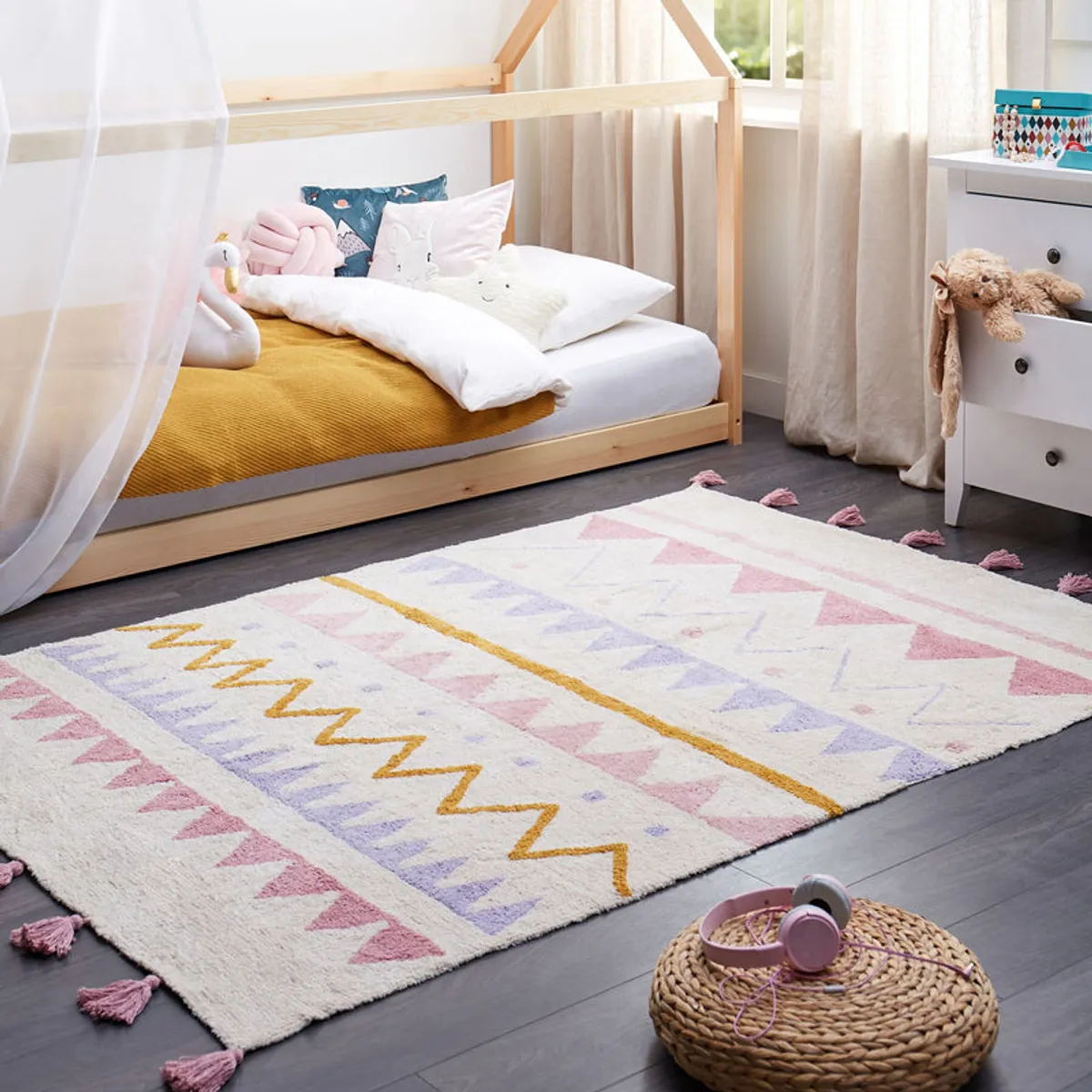 Multicolour geometric cotton rug with pink tassels styled in a children's bedroom