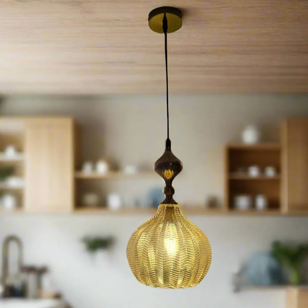 Gold pendant ceiling lamp against a blurred kitchen backdrop