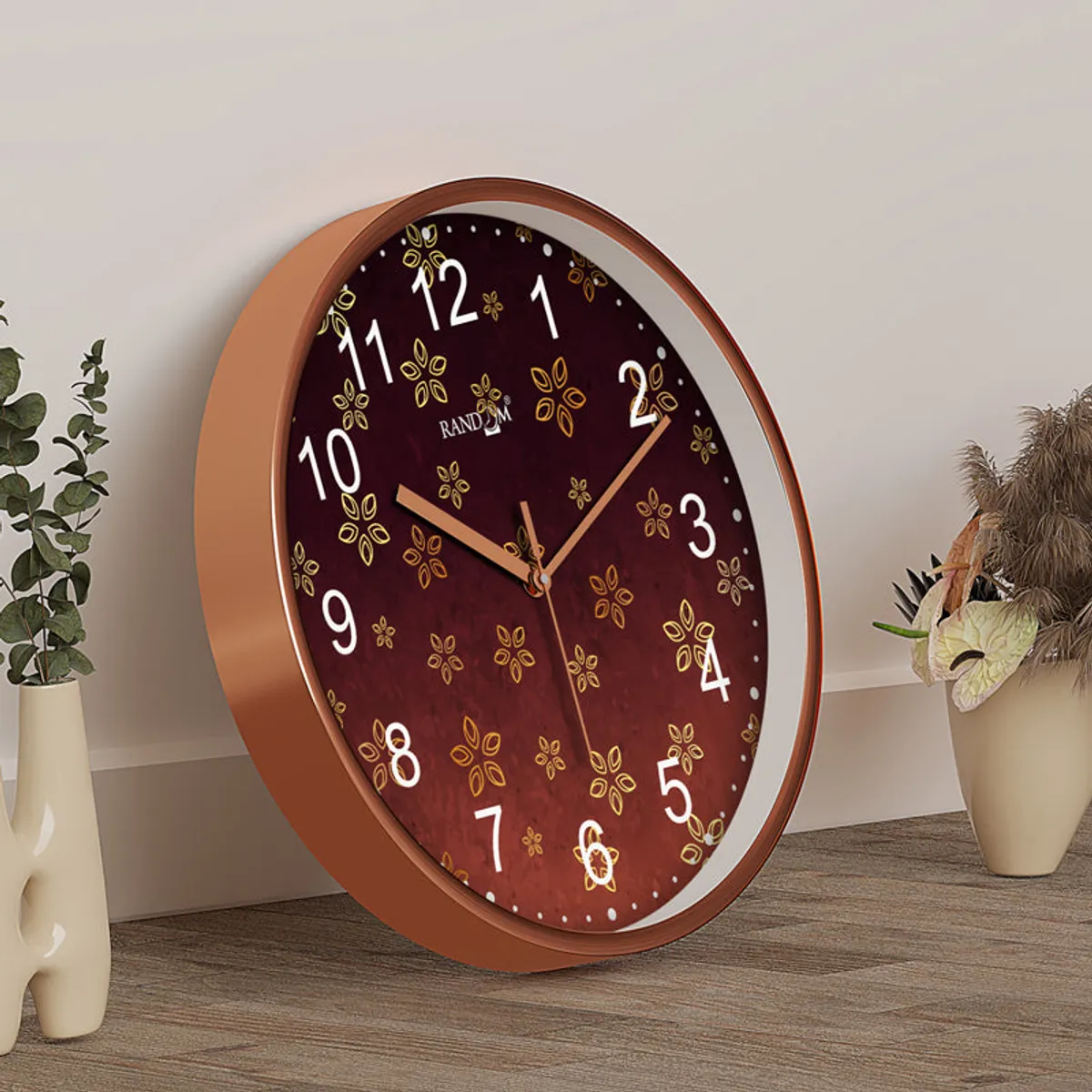 Side view of the round wall clock showing its copper-coloured depth and maroon face