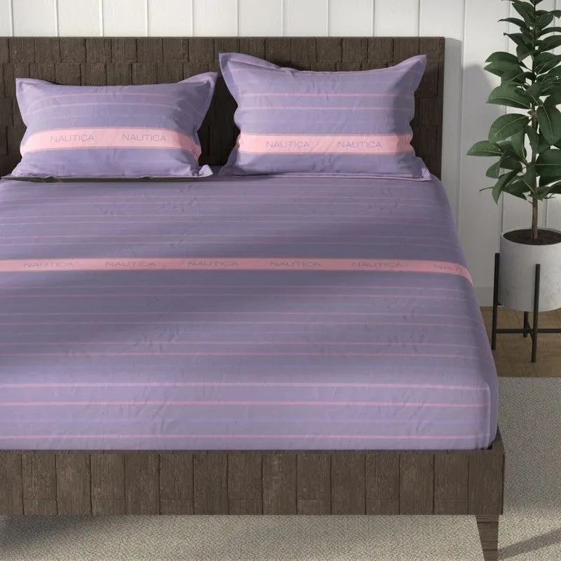 Purple striped bedsheet spread across a bed with matching pillow covers