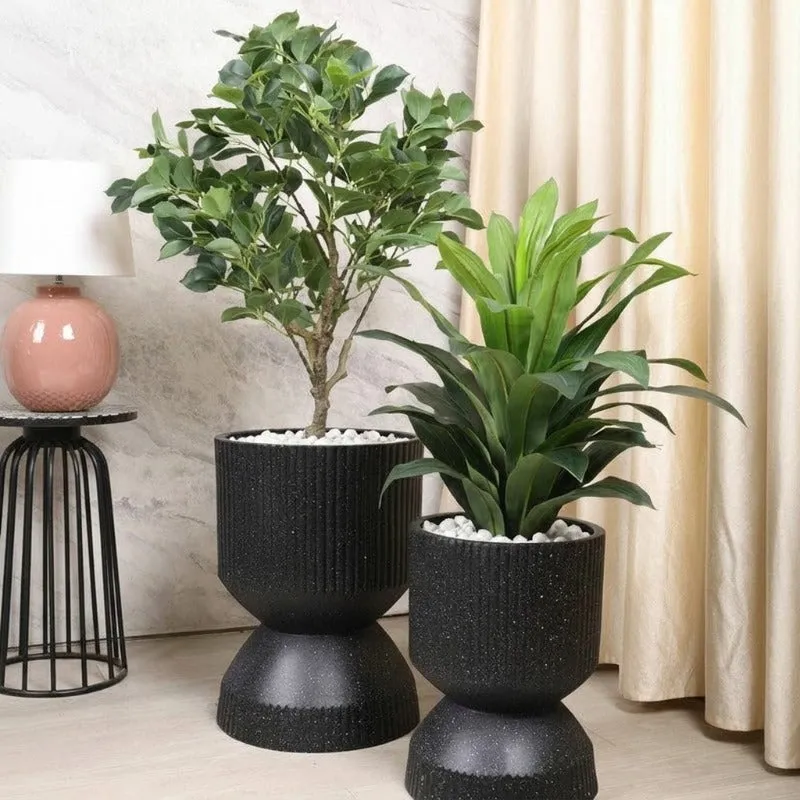 Two black ribbed planters in different sizes styled with indoor plants.