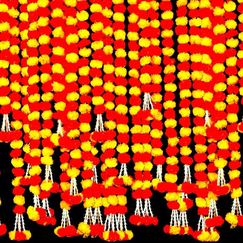 Close-up of red and yellow floral toran strands with hanging tassels