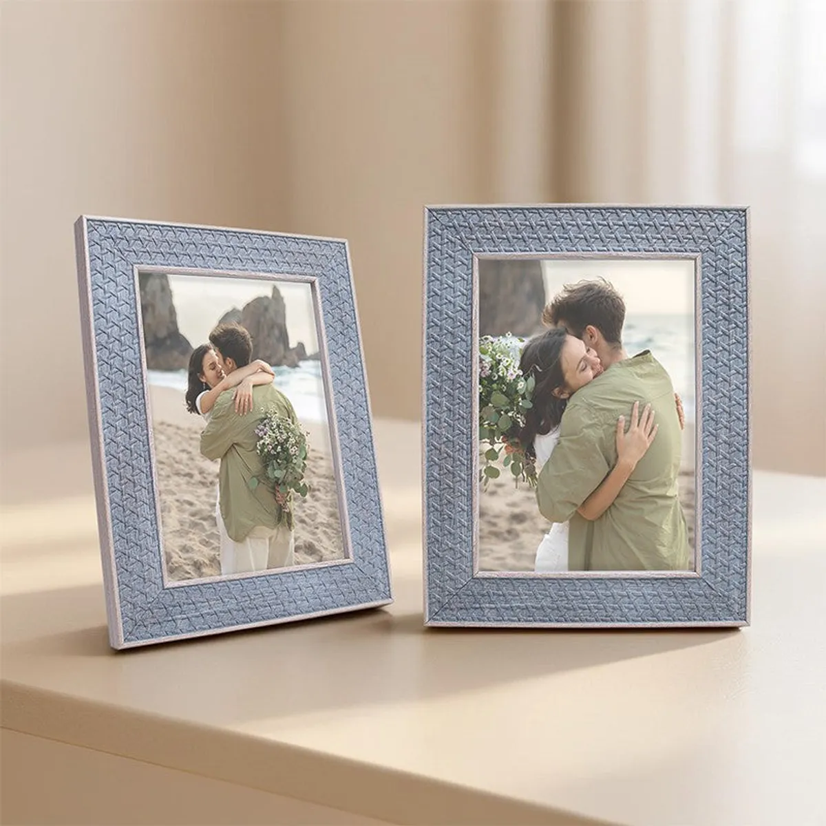 Two blue-grey photo frames arranged on a softly lit tabletop.