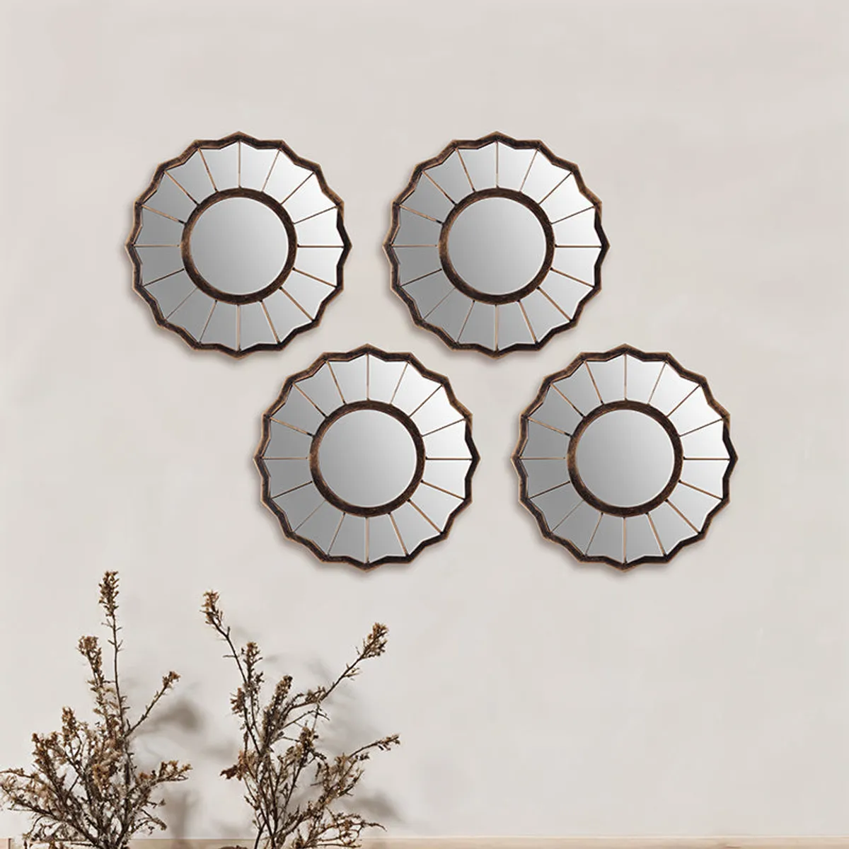 Four round decorative wall mirrors with scalloped sunburst edges arranged on a wall
