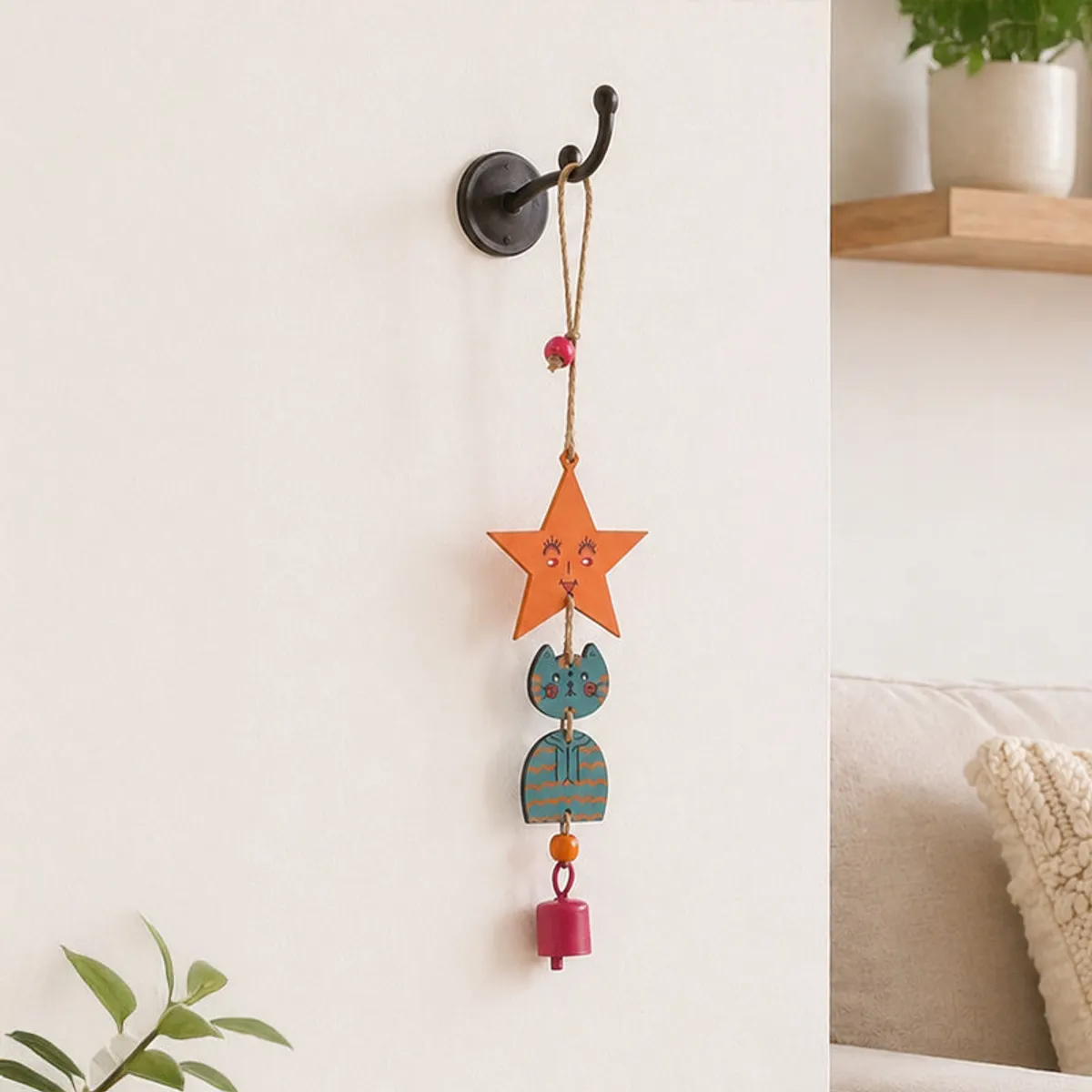 Kitty windchime hanging on a wall hook in a bedroom setting