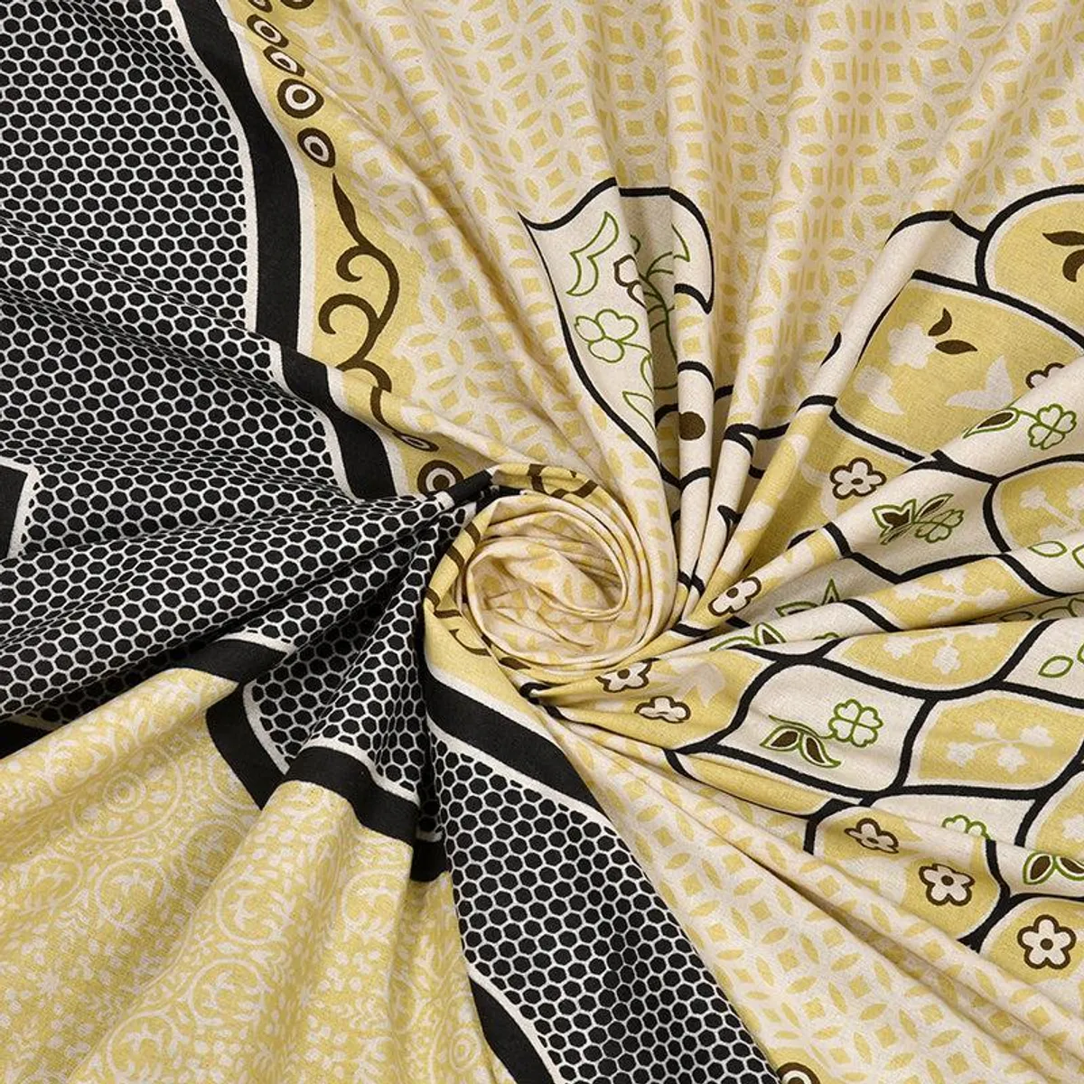 Close-up of the yellow printed cotton bedsheet fabric gathered to show drape