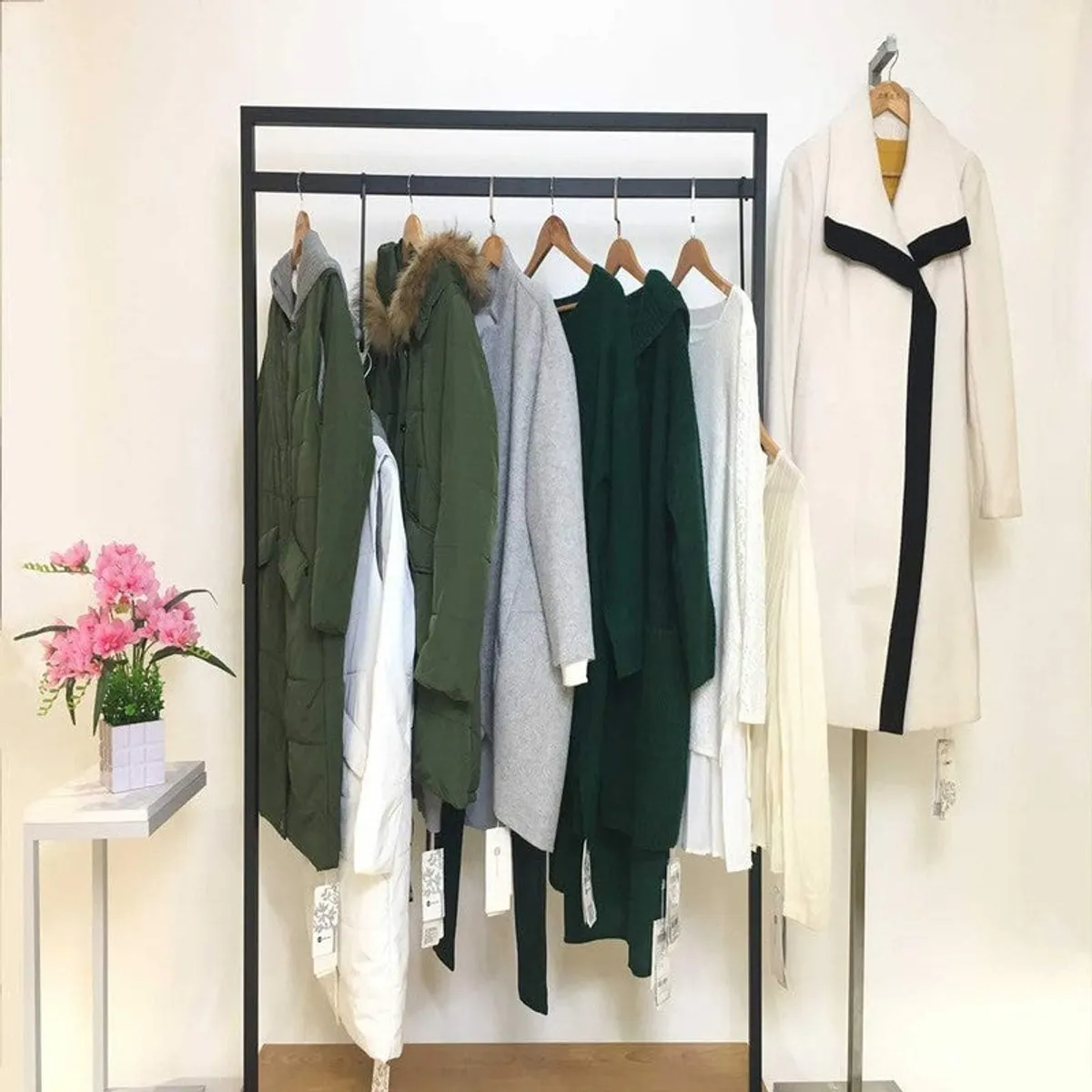 Clothing rack with multiple garments hung on matching wooden hangers