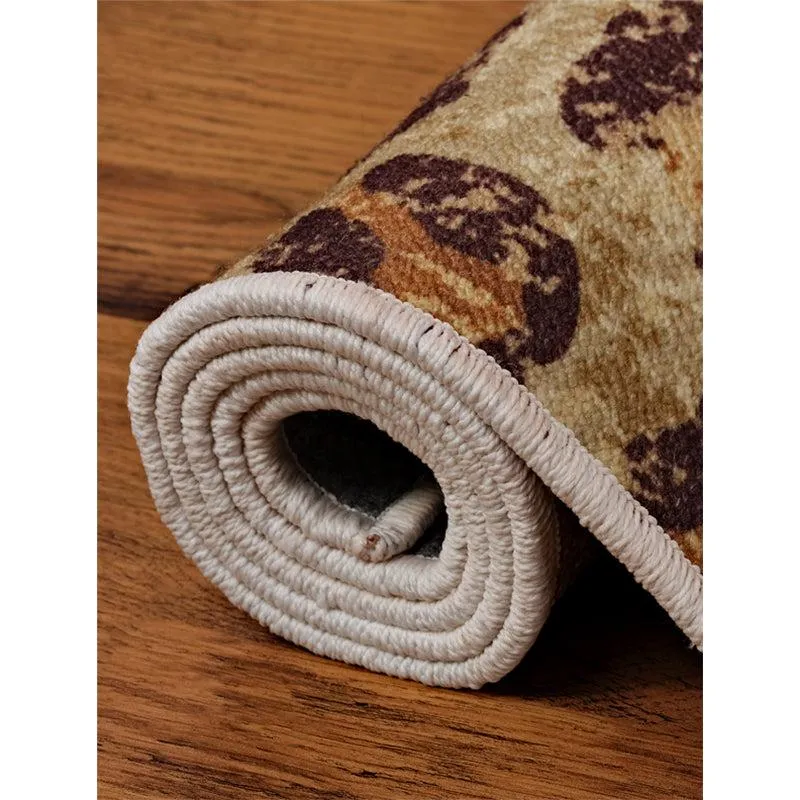 Rolled edge of the light brown patterned carpet on wooden flooring
