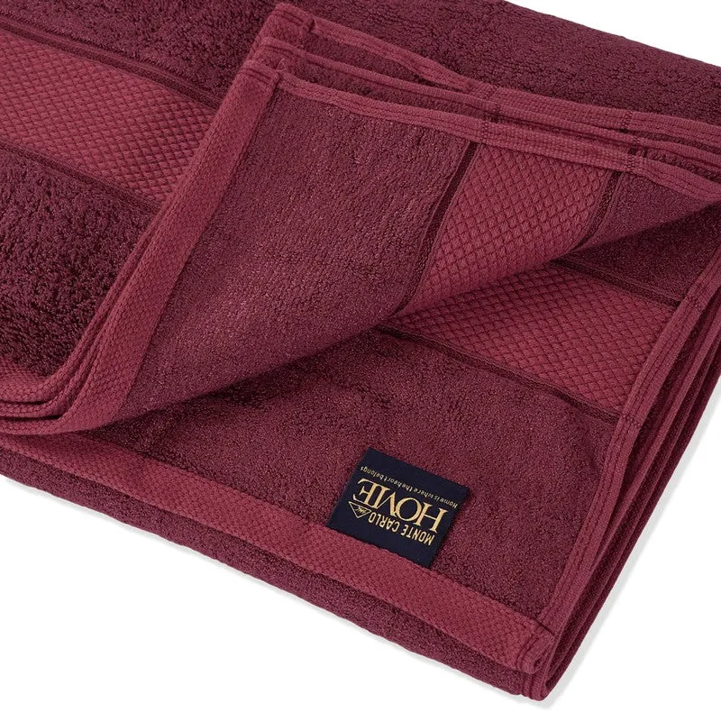 Close-up of folded maroon towel showing textured border detail