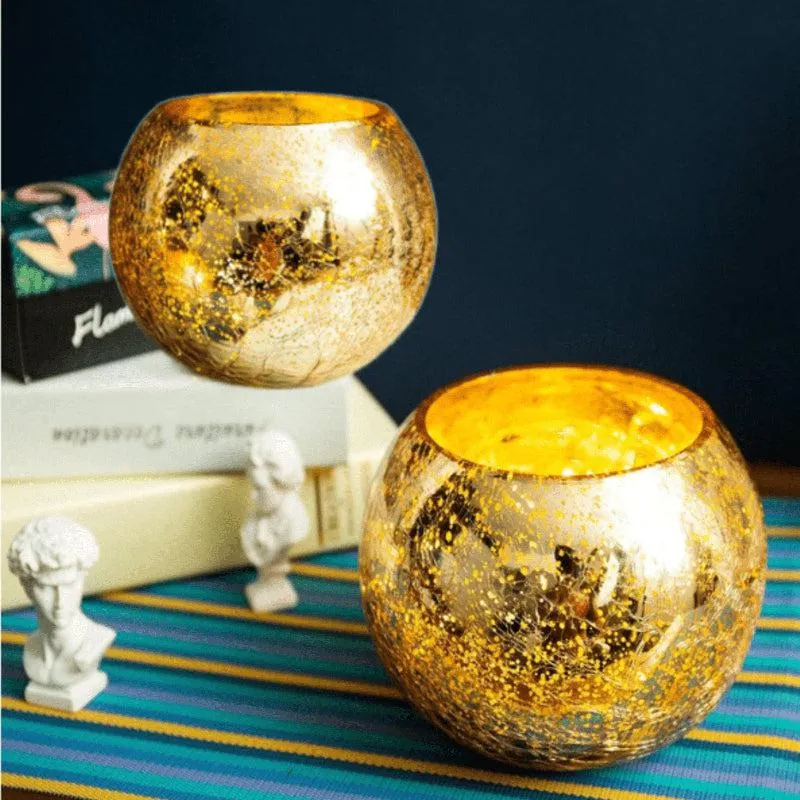 Two gold crackle-effect glass candle holders styled on books and a colourful runner