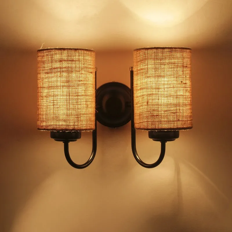 Close view of lit double-shade jute wall lamp with warm glow