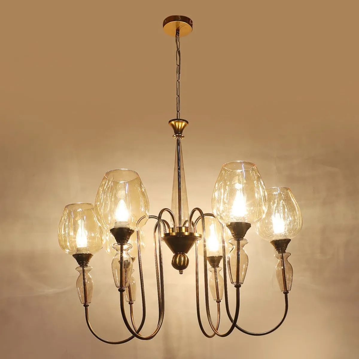 Gold chandelier glowing against a beige wall