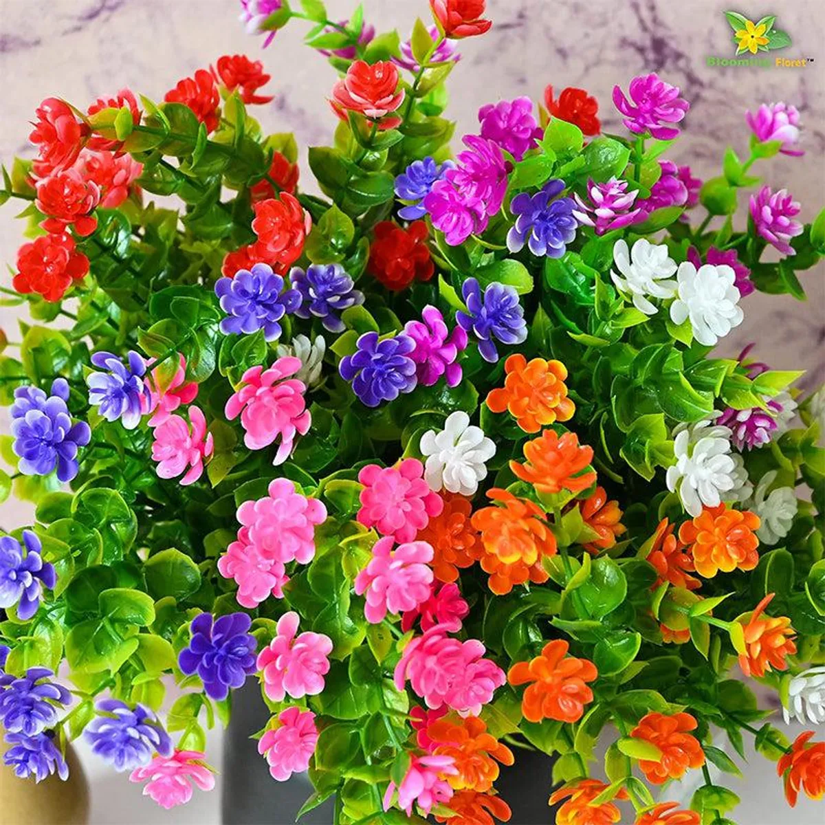 Close-up view of vibrant multicoloured artificial flowers and green leaves