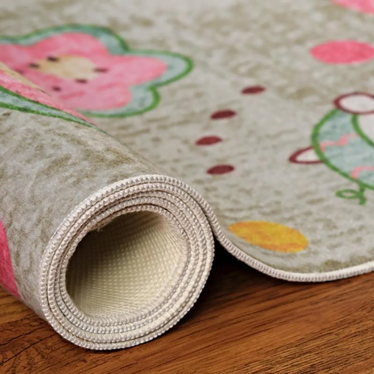 Rolled beige kids carpet showing printed surface and backing