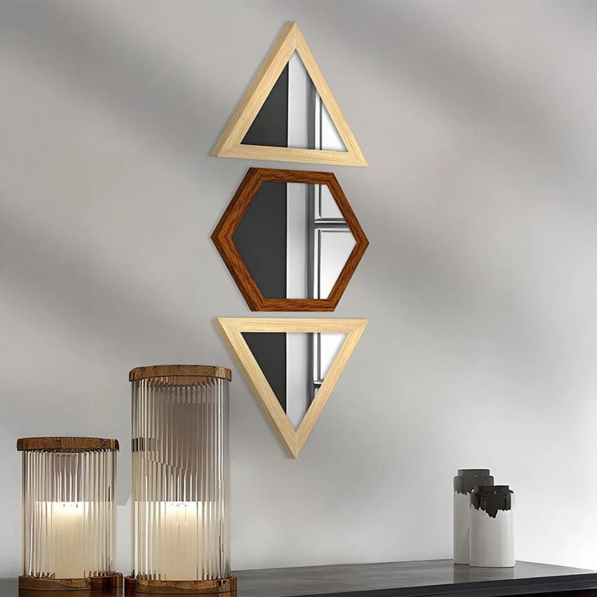 Three geometric wall mirrors in beige and brown displayed above a console