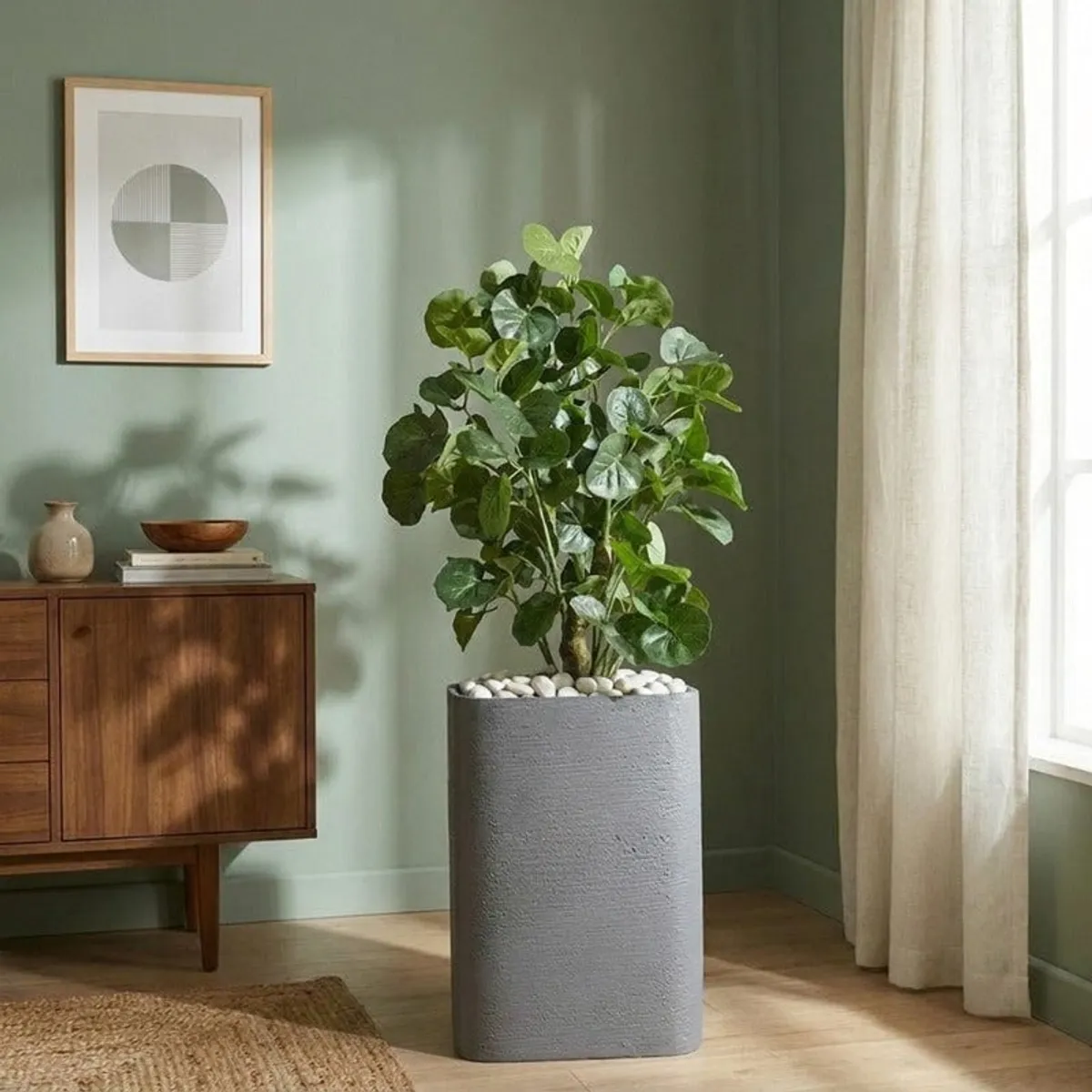 Grey floor planter holding a leafy plant against a green wall