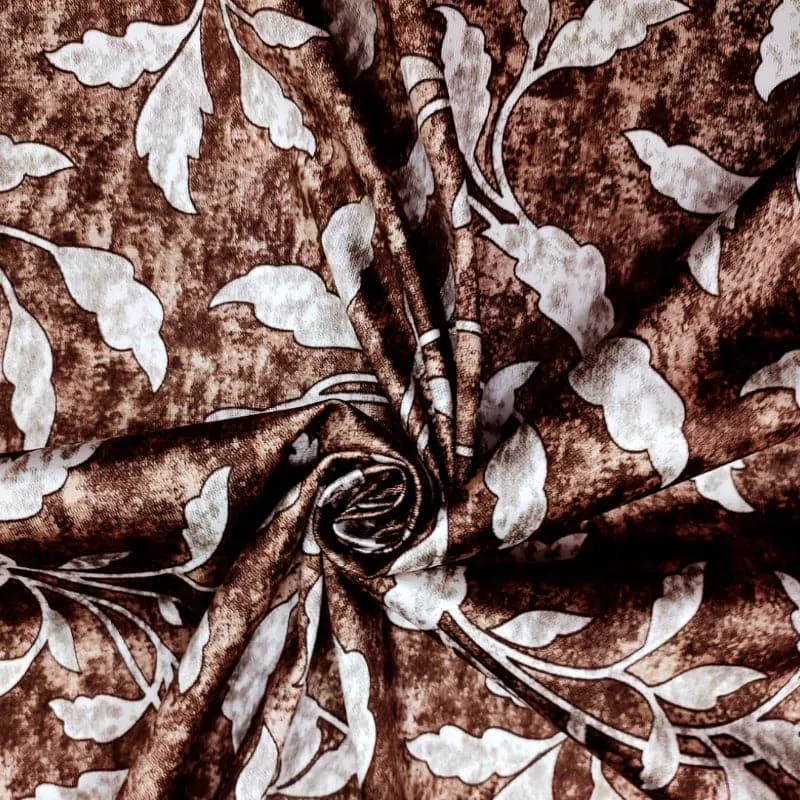 Close-up of brown floral curtain fabric with pale leaf motifs and a soft sheen.