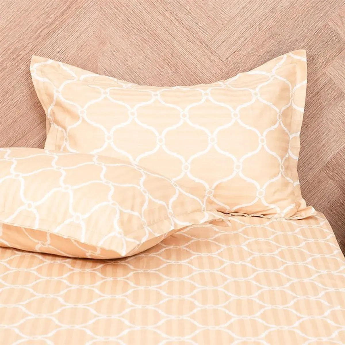 Close-up of matching pillow covers and bedsheet in a yellow geometric pattern