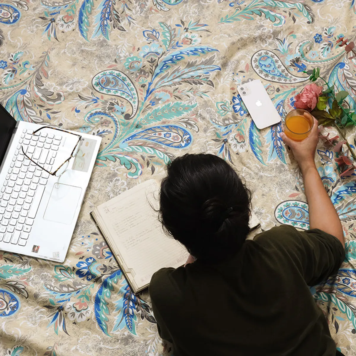 Close-up of ivory comforter with intricate blue and green paisley florals