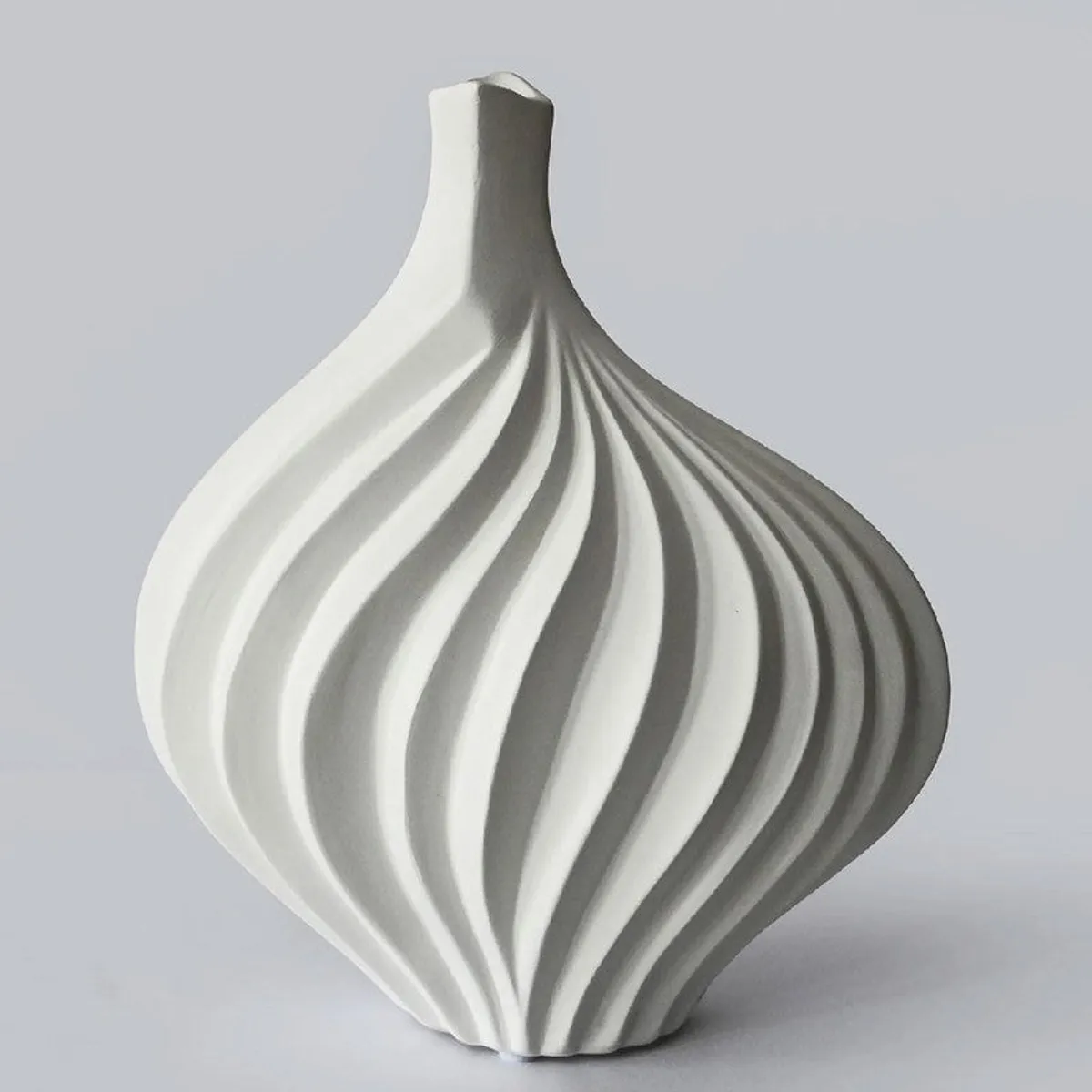 Close-up of a white ceramic vase with a rounded ribbed silhouette
