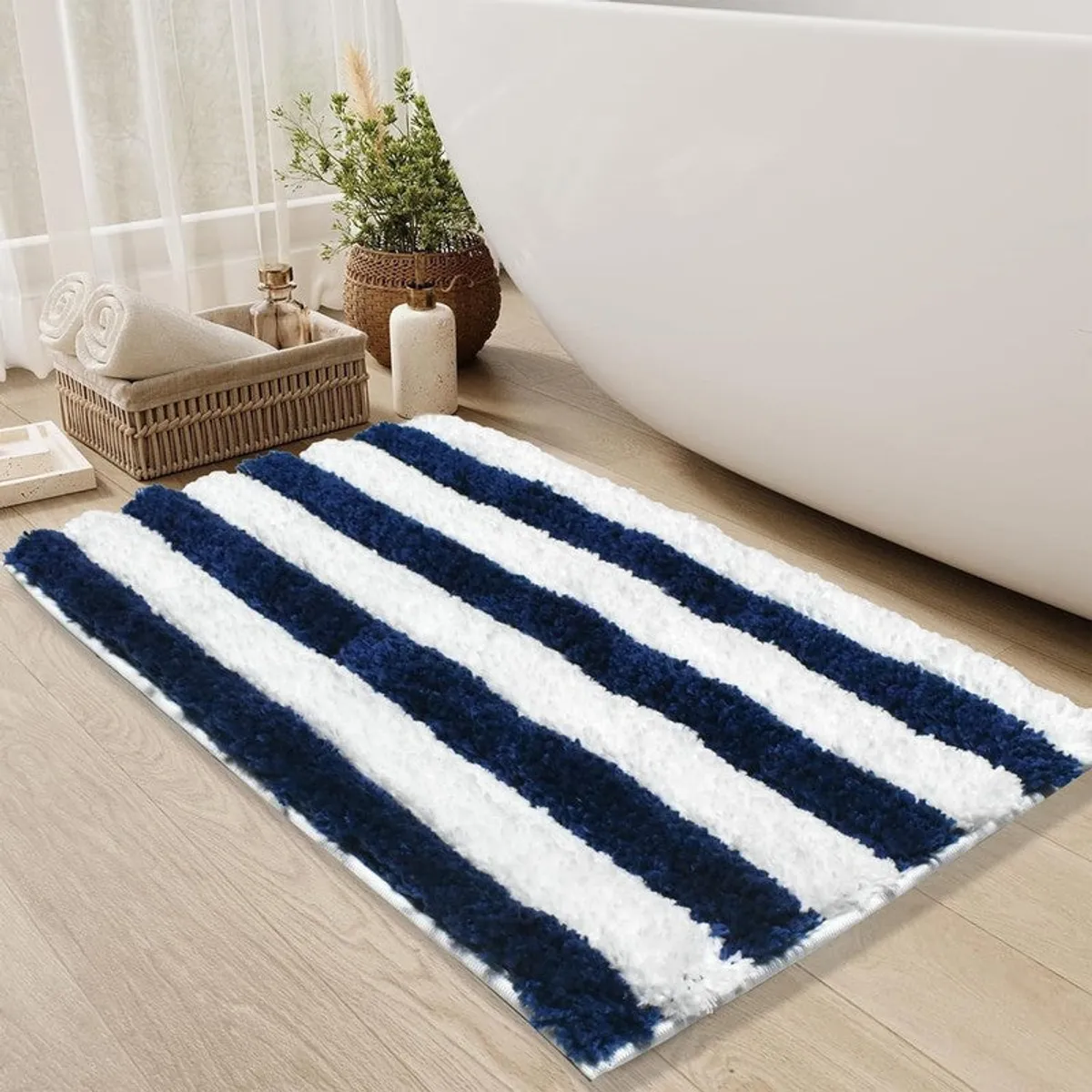 Blue and white striped bath mat styled next to a freestanding tub