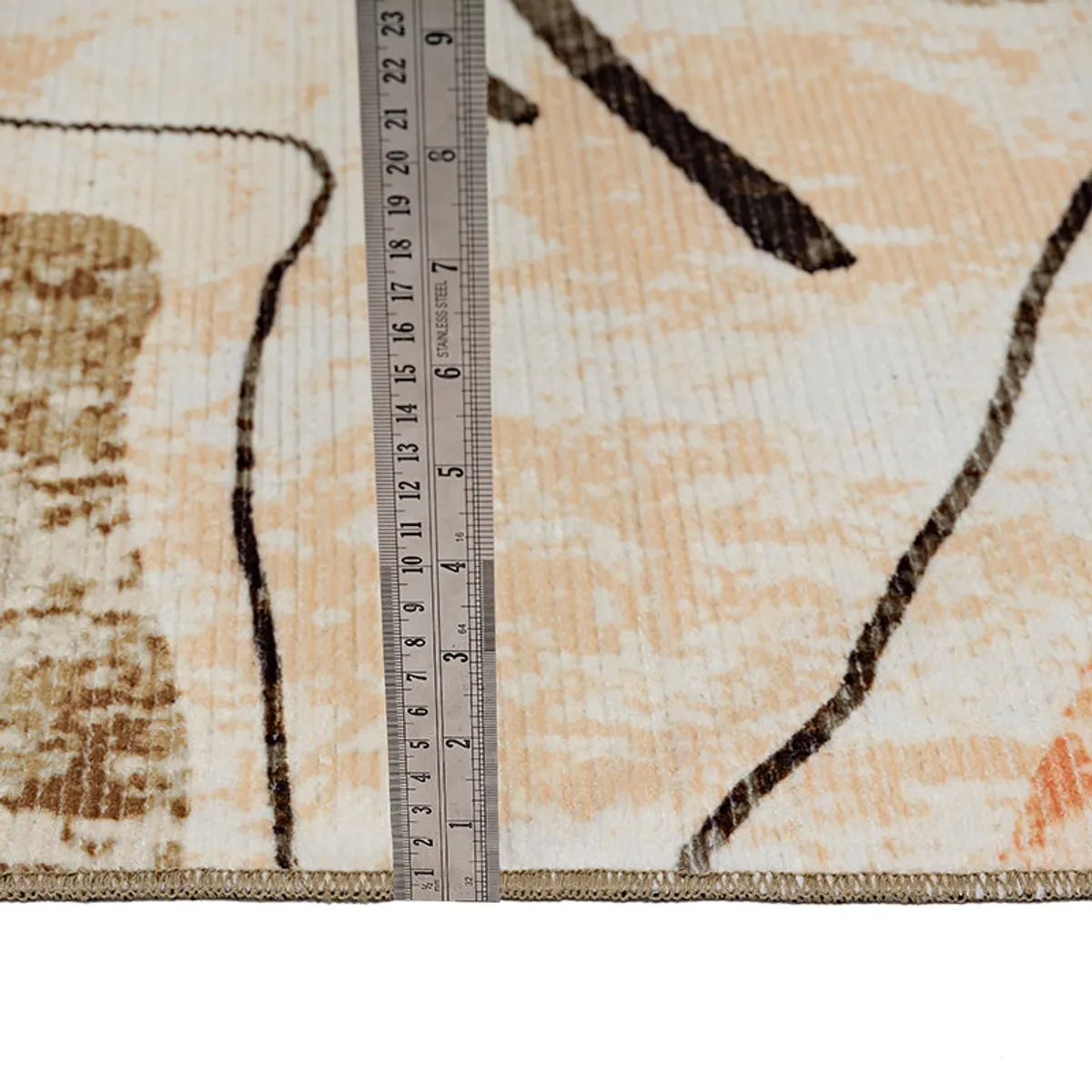 Close-up of carpet edge with ruler placed beside it