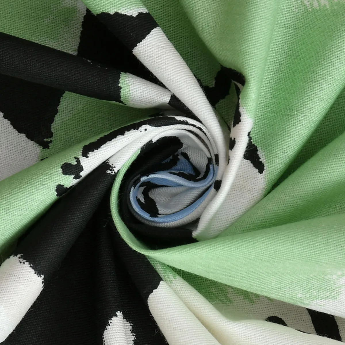 Close-up view of the green, black and white printed bedsheet fabric