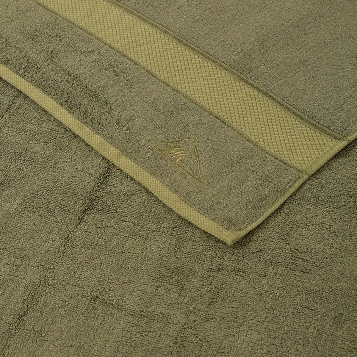 Close-up of the olive green towel's soft textured surface and border