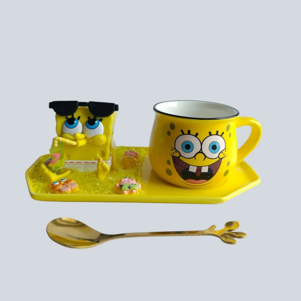 Yellow ceramic SpongeBob mug and figurine arranged on a tray