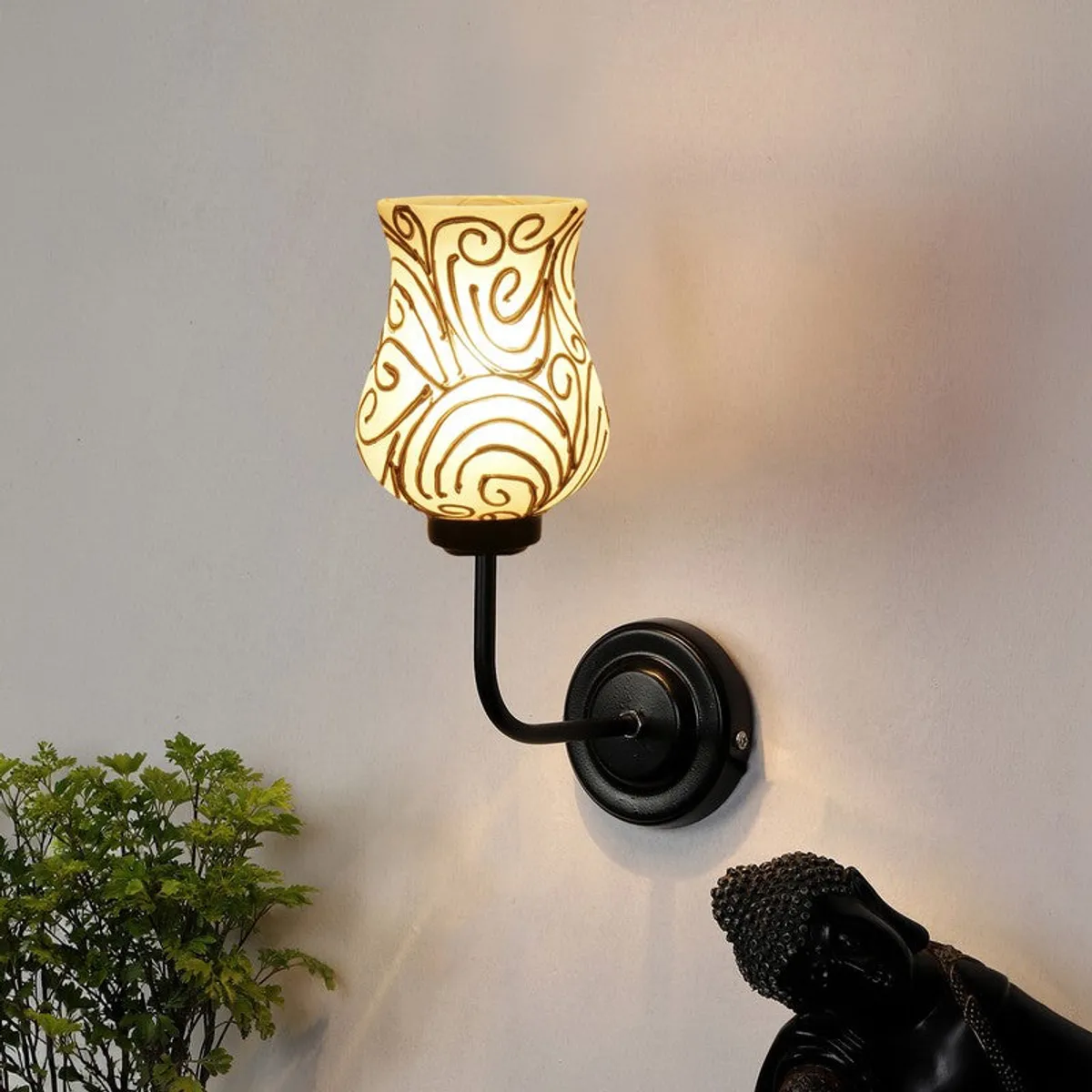 Lit wall lamp with white glass shade and gold swirl pattern