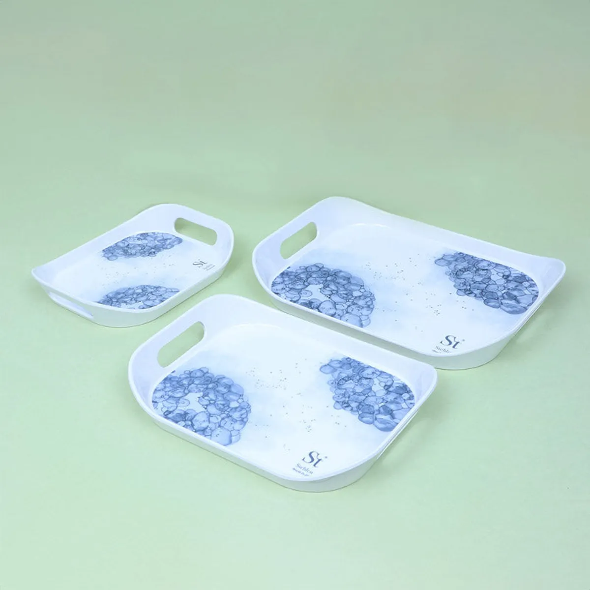Large, medium and small white trays with blue floral motifs displayed together.