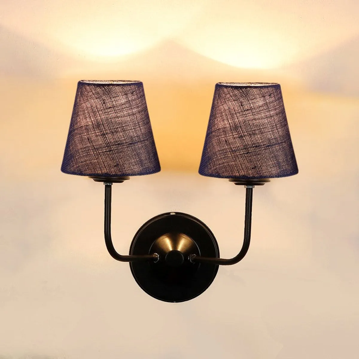 Front view of lit blue jute twin wall lamp with black round mount