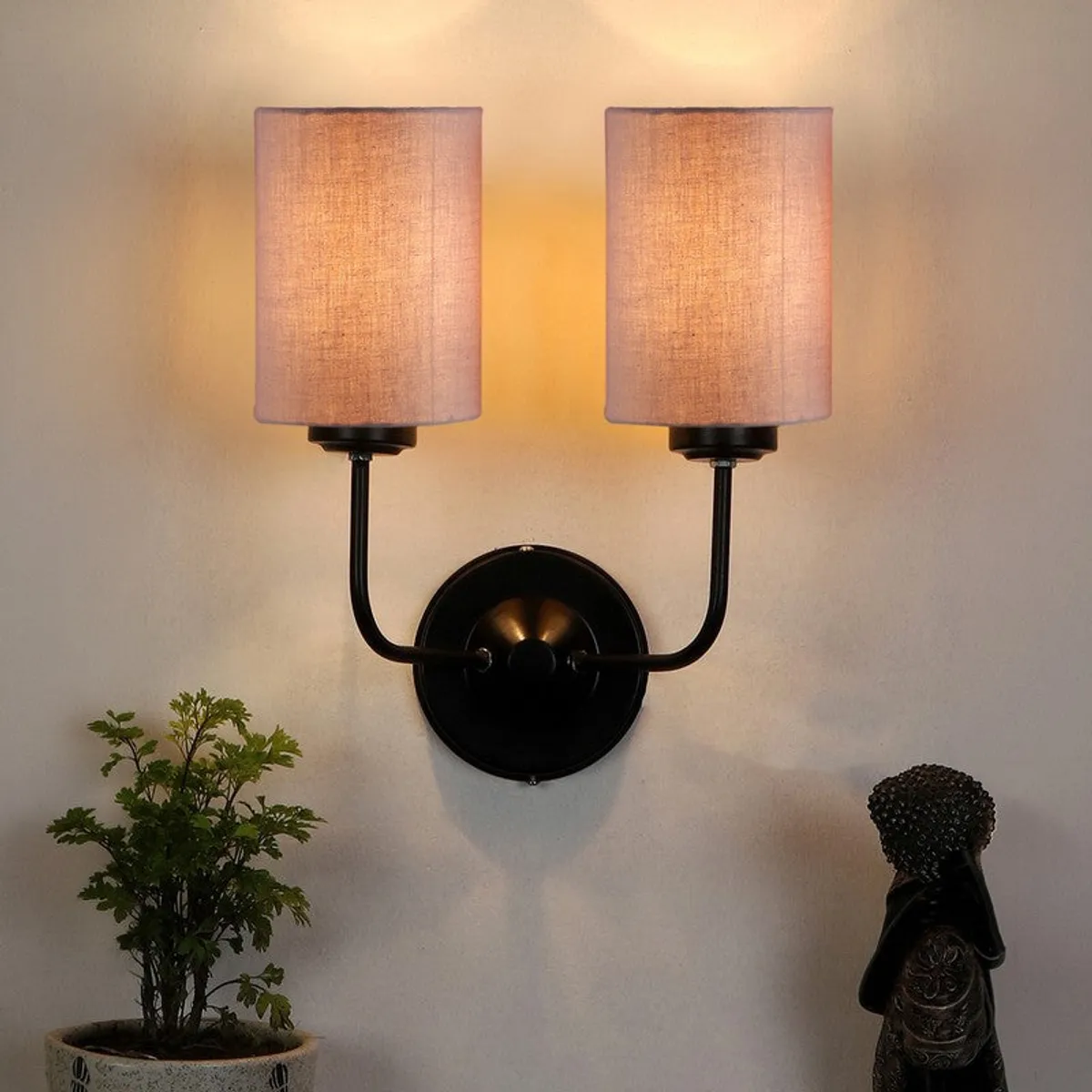 Beige jute wall lamp glowing warmly on a wall
