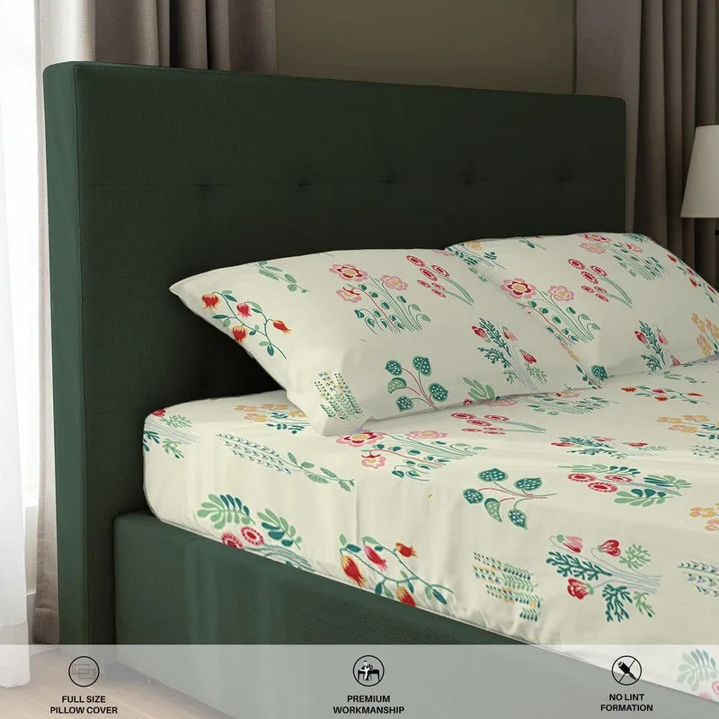 Close-up of floral fitted bedsheet and pillow cover on a dark green bed