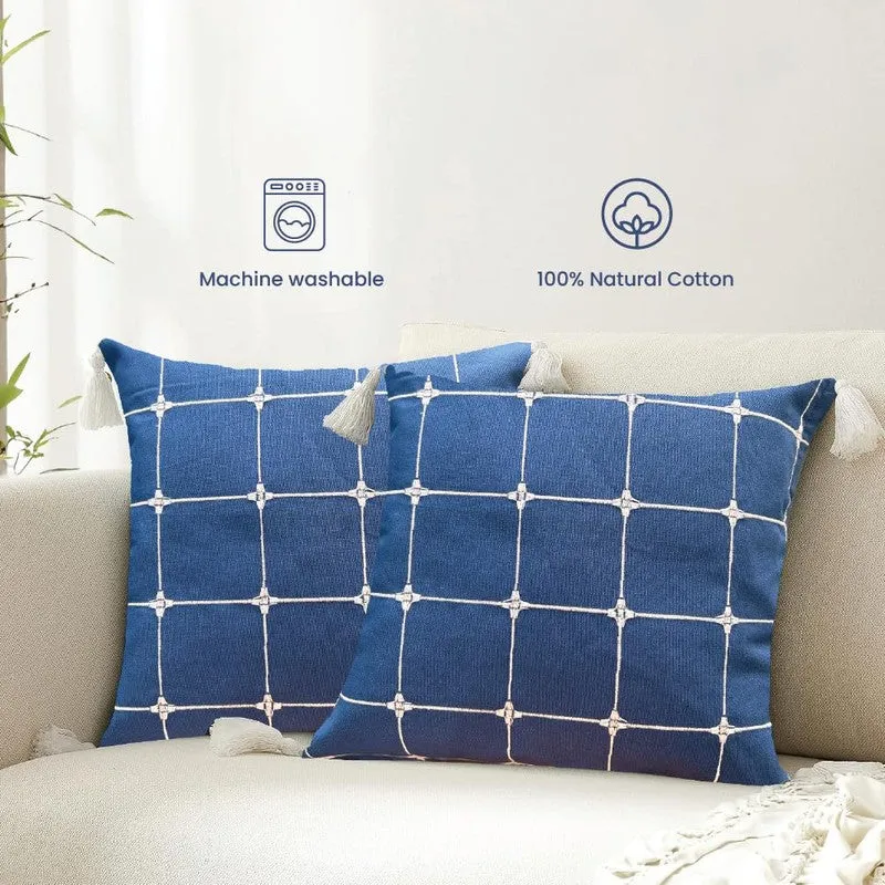 Two blue checked cushion covers with tassels styled on a cream sofa