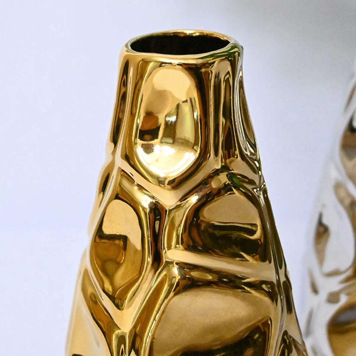 Close-up of the gold vase with a reflective textured surface
