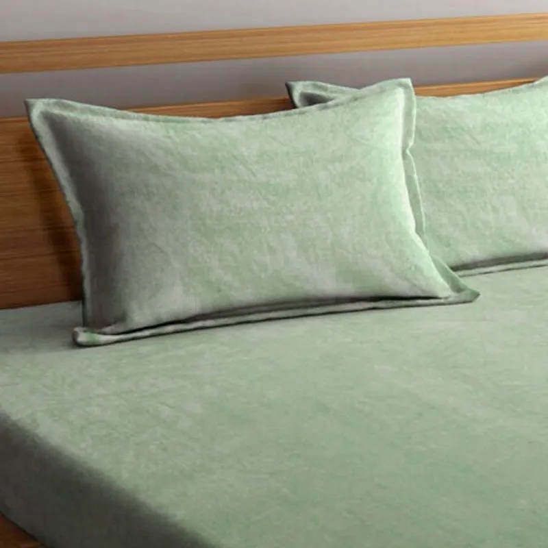 Close-up of matching sea green pillow covers on the bedsheet