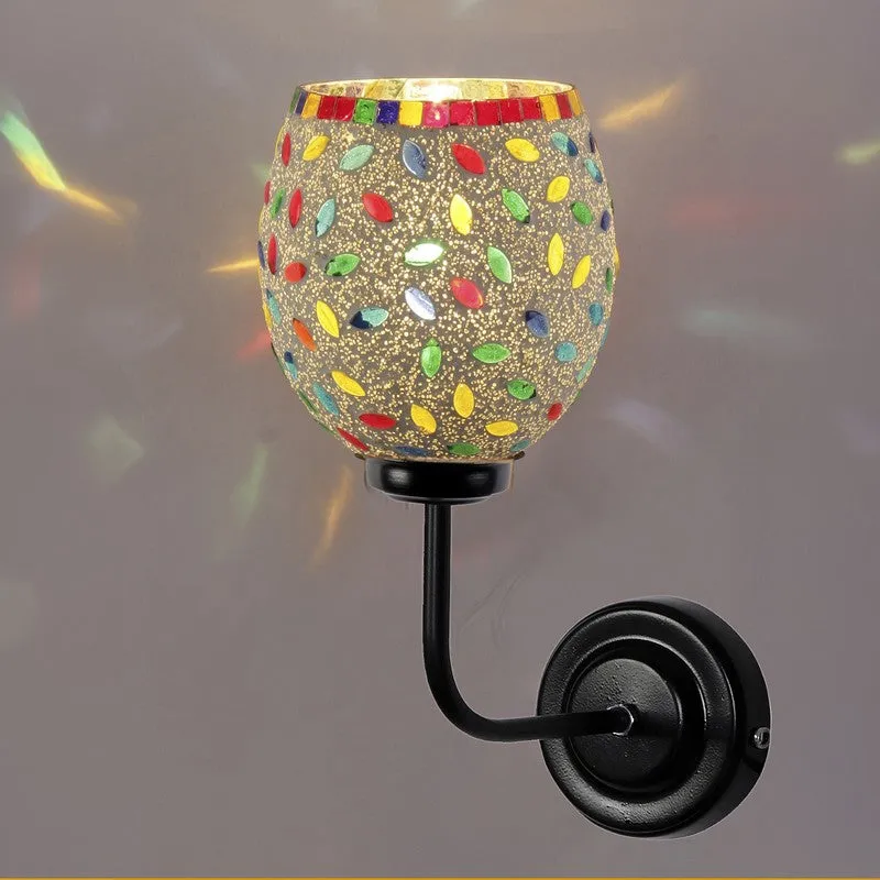 Multicolour mosaic glass wall lamp glowing against a neutral wall